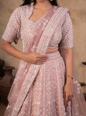 Close-up of the blush pink lehenga's stitched V-neck blouse with silver sequin work and the embroidered dupatta border