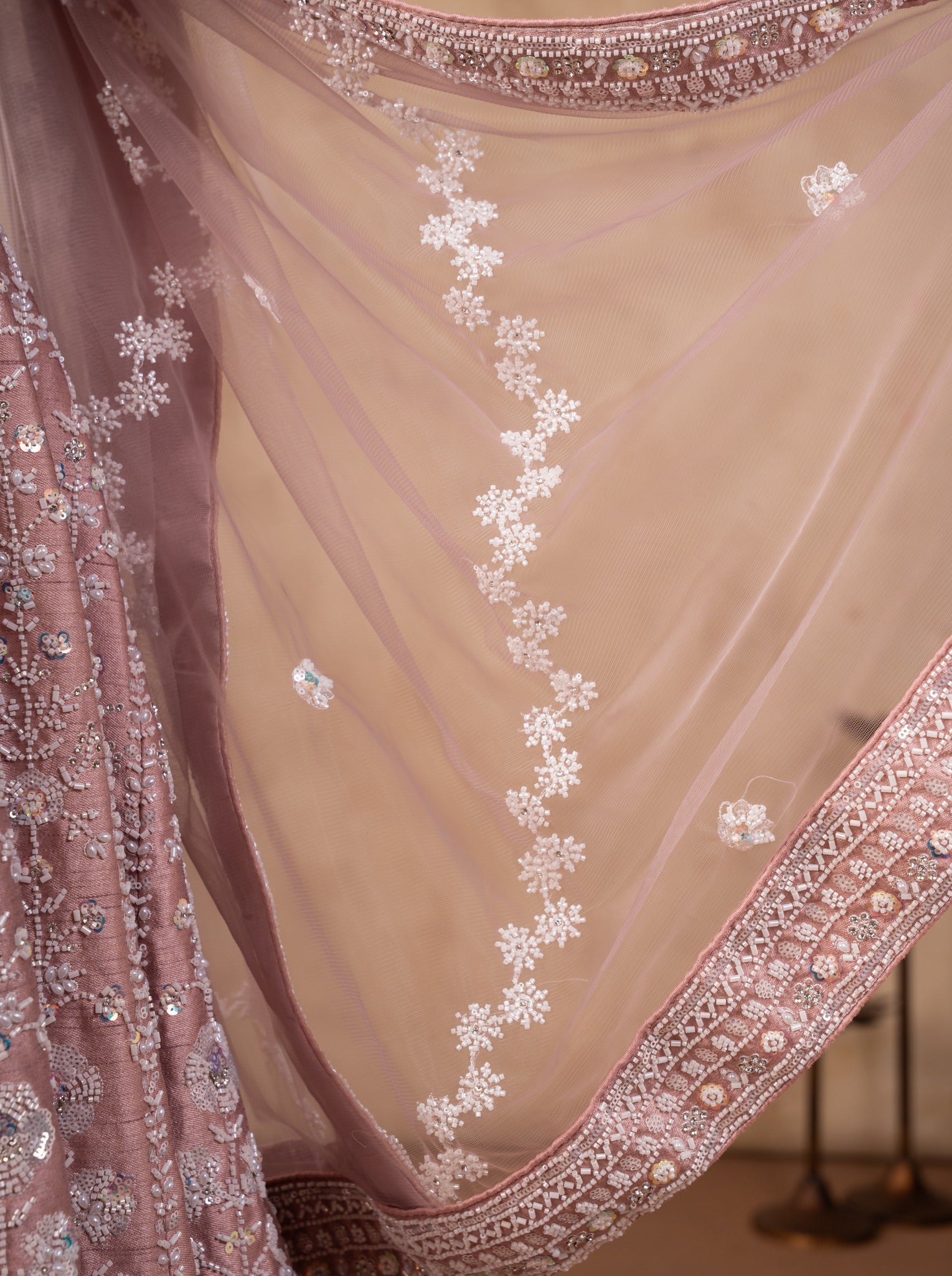 Detail of the sheer blush pink net dupatta with scattered floral embroidery and an embellished border