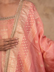 Close-up of the blush pink Anarkali's embellished neckline and the dupatta's woven gold motifs and border