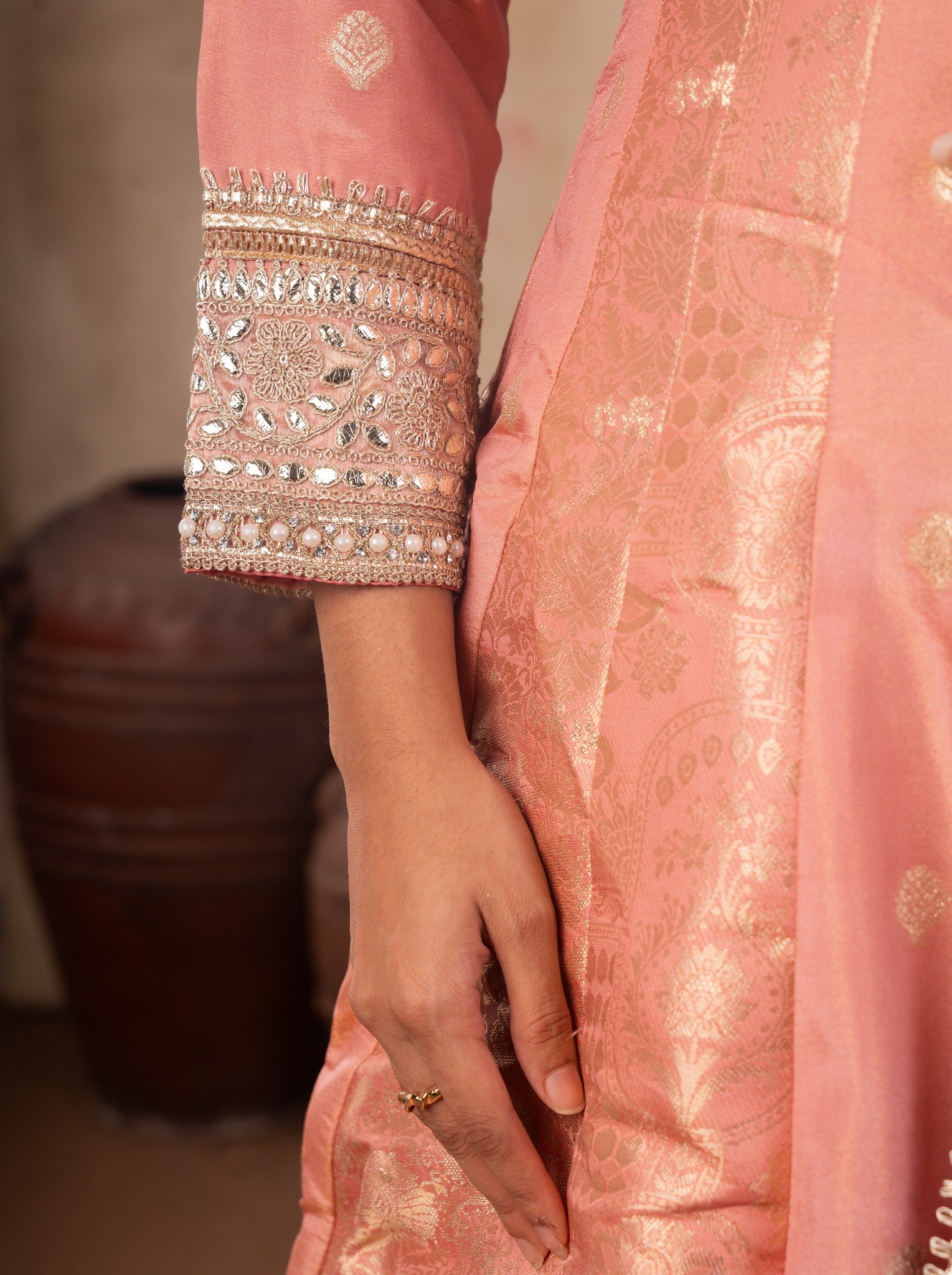 Detail of the embellished cuff on the blush pink raw silk Anarkali sleeve with the gold-woven dupatta