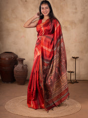 Model in a maroon checked tussar silk saree with a sleeveless blouse, one hand raised to her hair