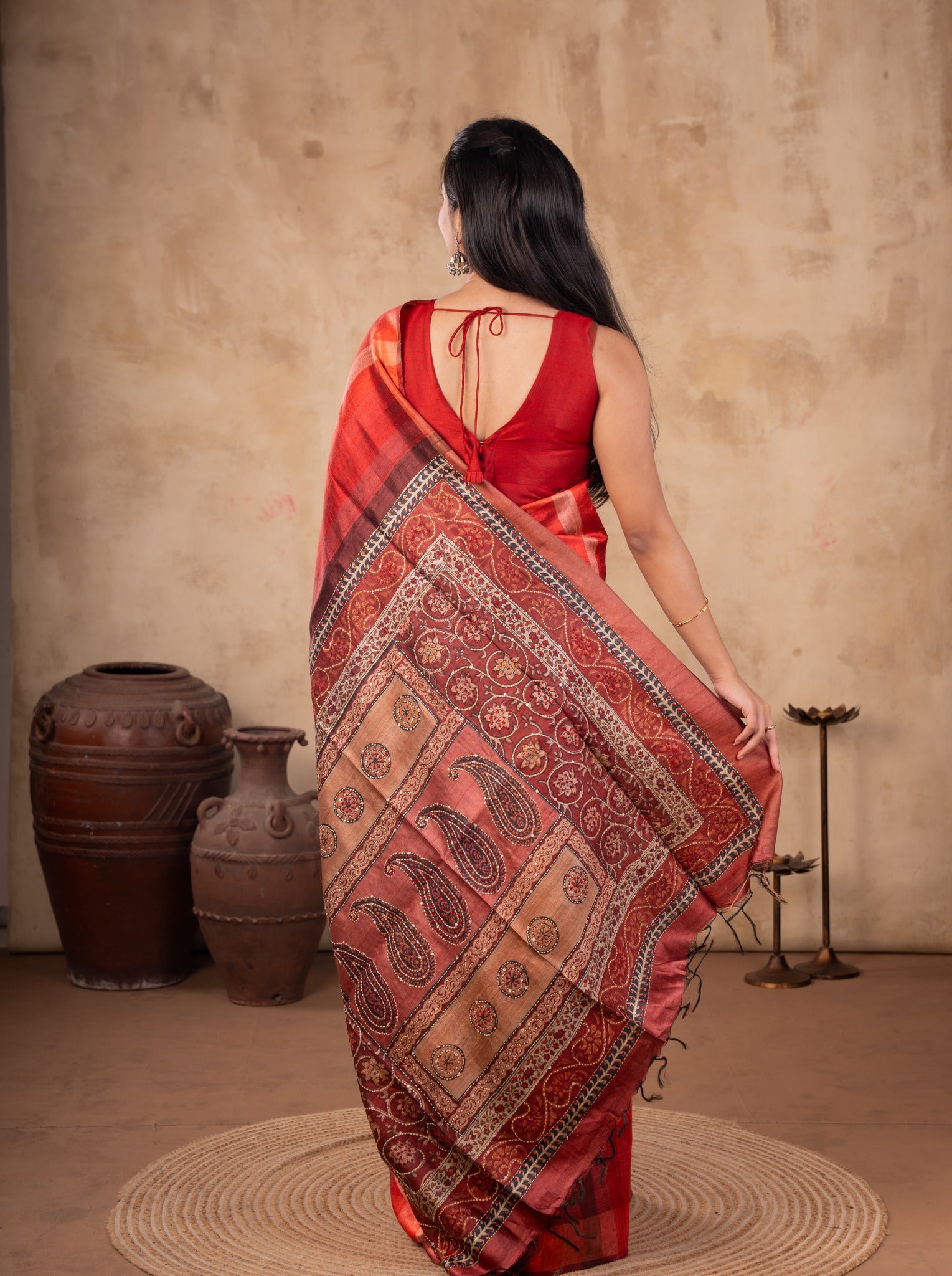 Back view of a maroon tussar silk saree showing the paisley-patterned pallu and back of the blouse