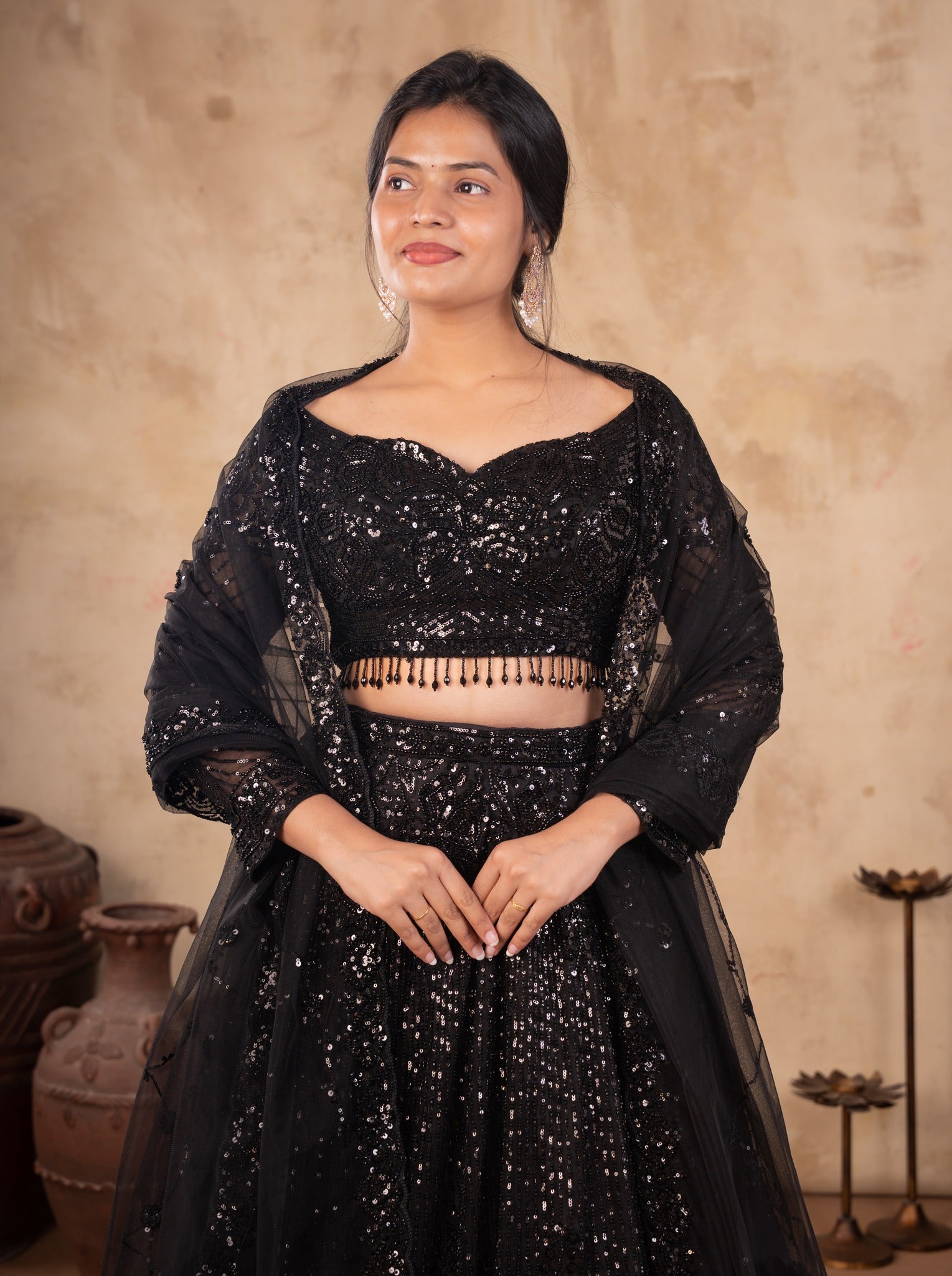 Half-length view of a black net lehenga with a sweetheart-neck blouse, beaded fringe hem and a sheer dupatta
