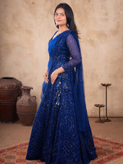 Model in a royal blue net lehenga with shimmering sequin embellishments, sheer sleeves and a draped dupatta
