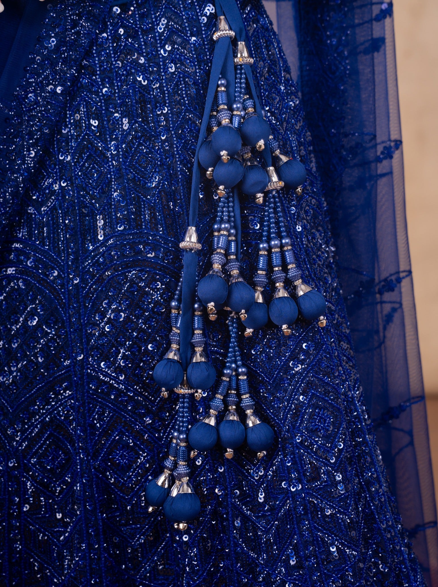 Detail of the royal blue beaded tassel latkan against the sequinned net skirt