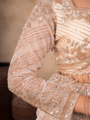 Detail of the sheer embroidered sleeve and sequin work on the cream lehenga blouse