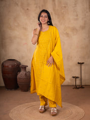 Front view of a model in a yellow cotton salwar suit with a sleeveless sequinned kurta, matching pants and a dupatta over one shoulder