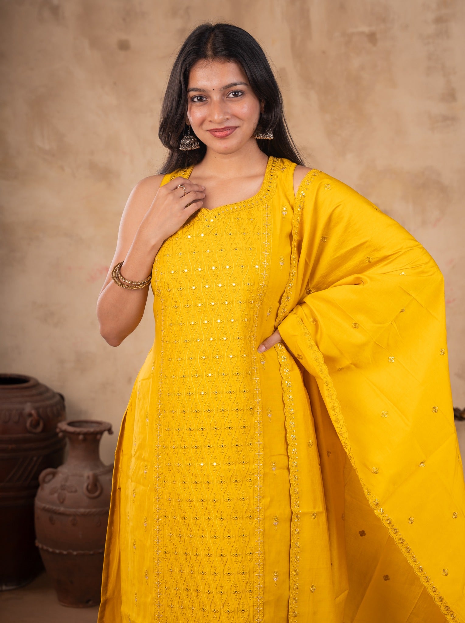 Half-length view of a yellow cotton kurta with subtle sequin detailing and a draped yellow dupatta