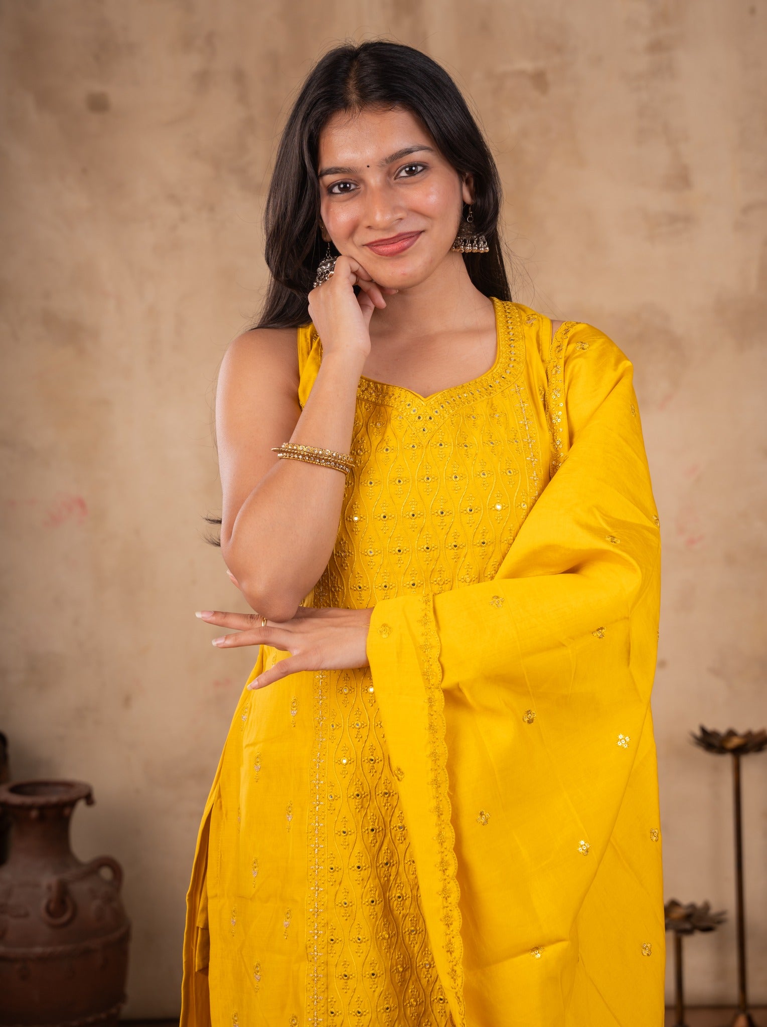Model smiling in a yellow cotton salwar suit with the dupatta held across her body