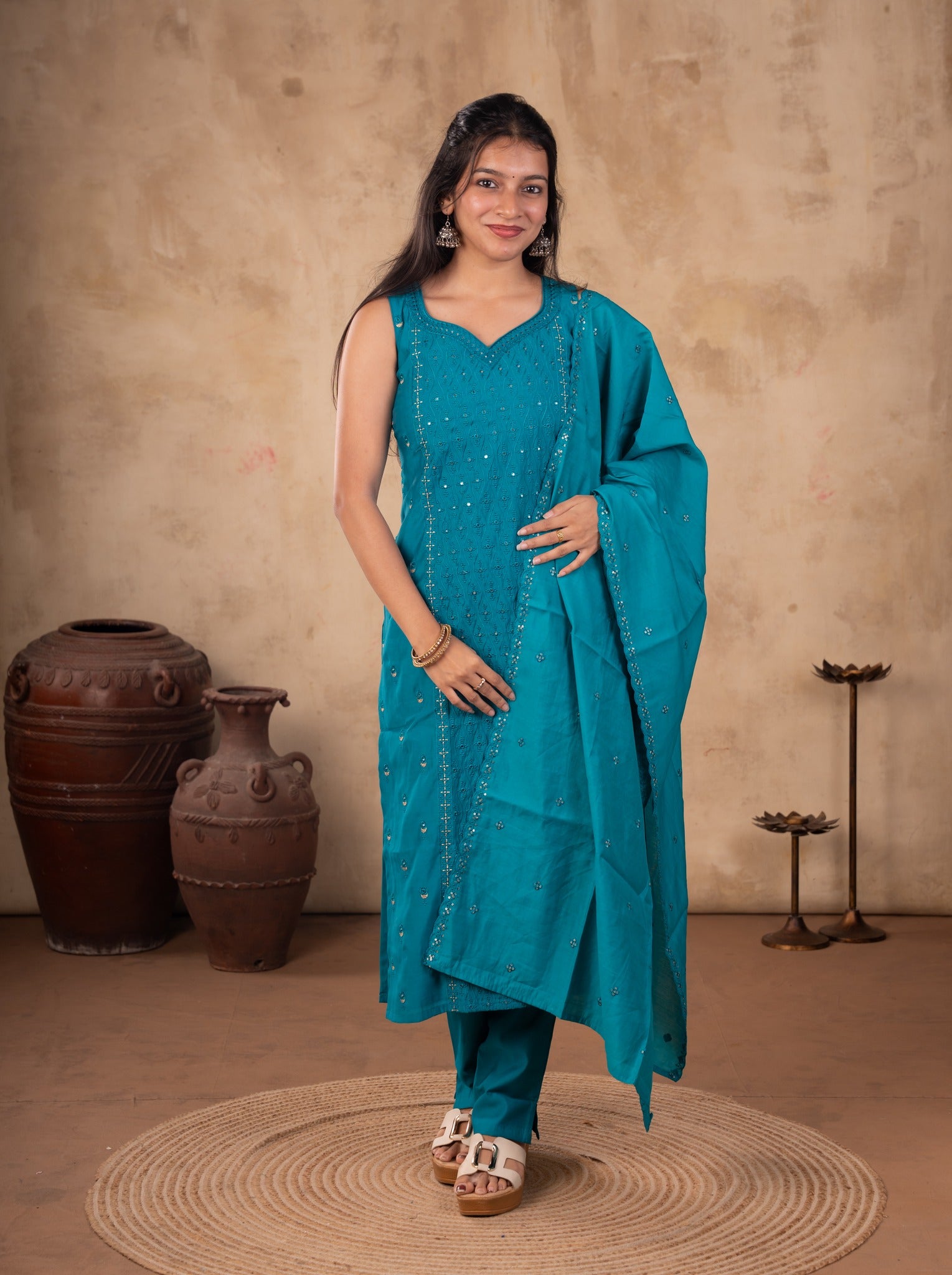 Front view of a model in a Rama teal cotton salwar suit with a sleeveless embellished kurta, matching trousers and a dupatta