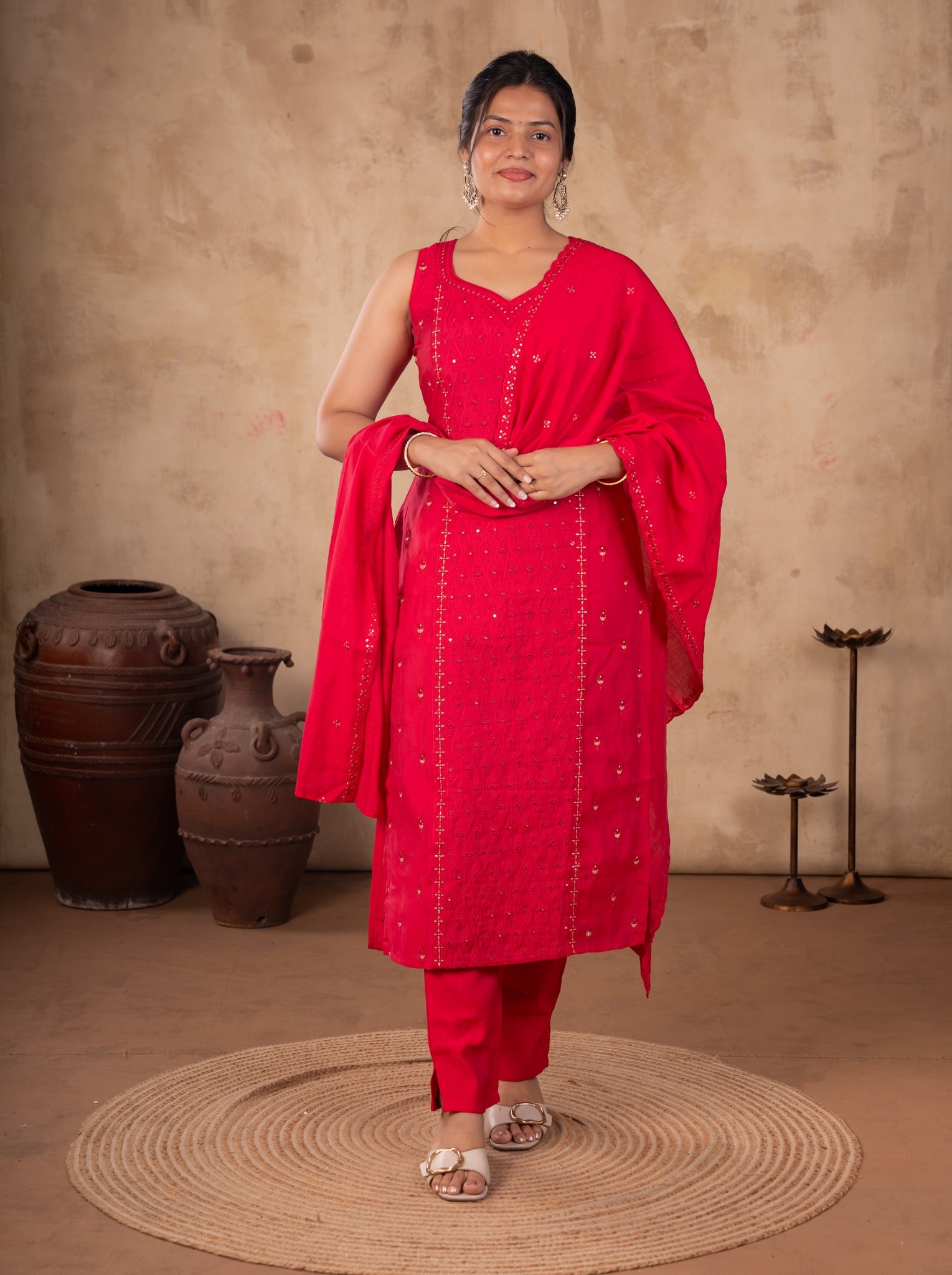 Front view of a model in a Rani pink cotton salwar suit with a sleeveless embellished kurta, matching trousers and a dupatta