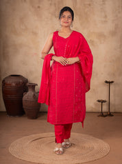 Front view of a model in a Rani pink cotton salwar suit with a sleeveless embellished kurta, matching trousers and a dupatta