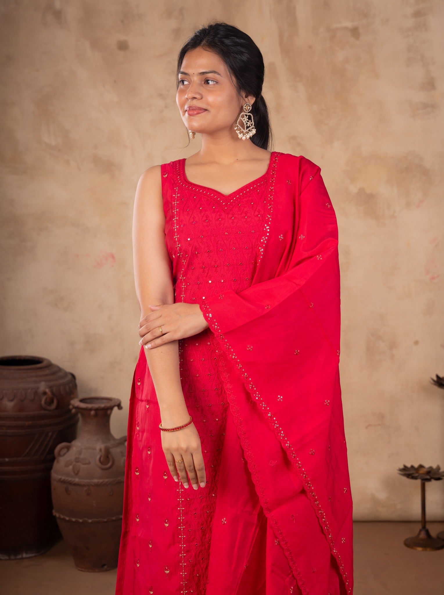 Model smiling in a Rani pink cotton salwar suit with the dupatta draped over one shoulder