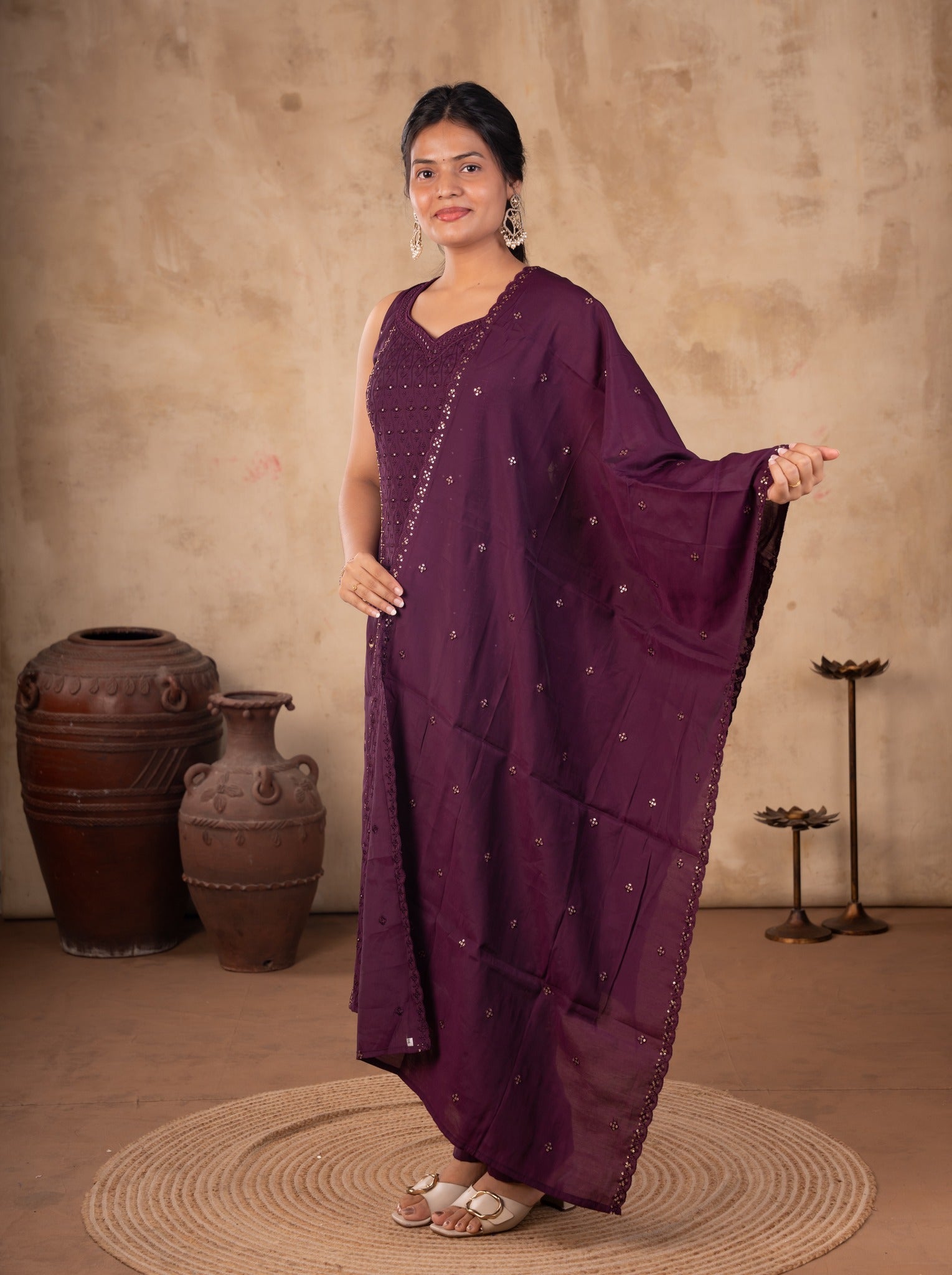 Full-length view of a purple cotton salwar suit with the dupatta draped over one arm