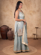 Full-length view of a sea green silk salwar suit showing the embroidered kurta hem and flared trousers
