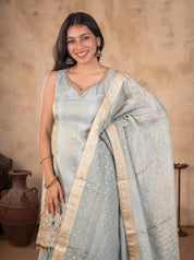 Model smiling in a sea green silk salwar suit with the dupatta draped over one shoulder