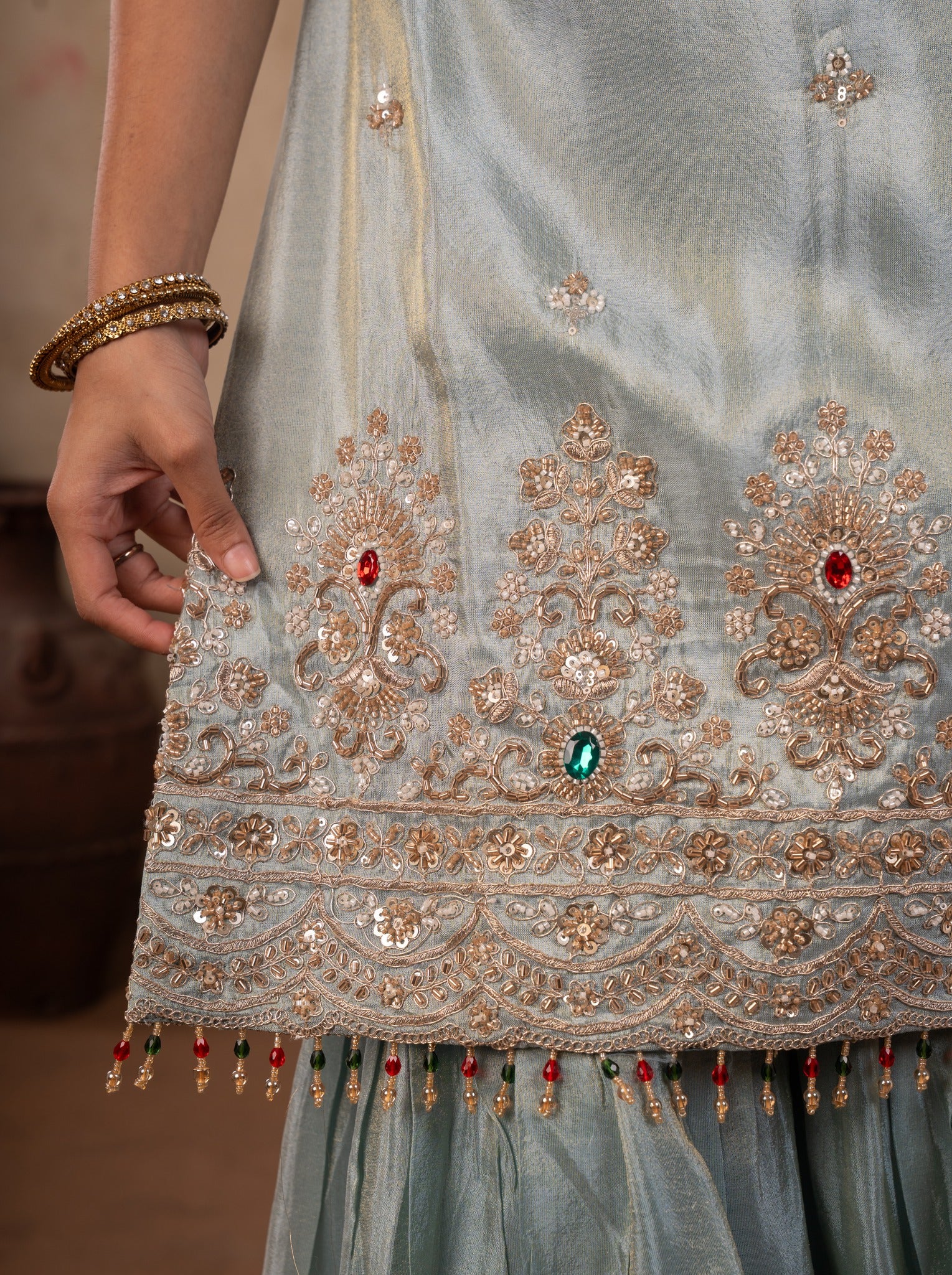 Detail of the stone and bead embroidery along the hem of the sea green silk kurta