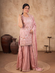Model in a peach silk salwar suit with the dupatta draped over one shoulder