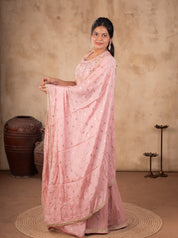 Model holding out the peach dotted dupatta over a silk salwar suit