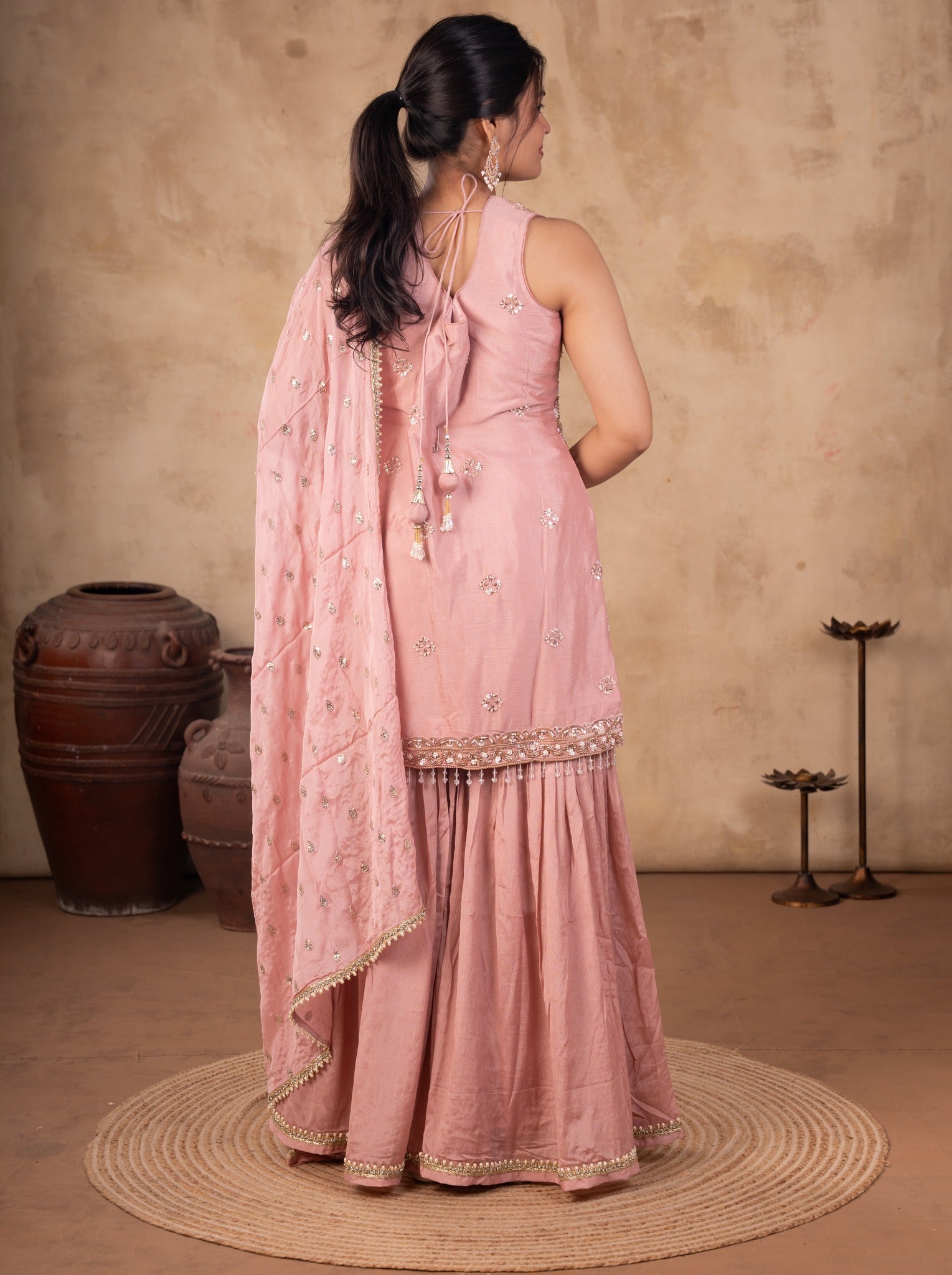 Back view of a peach silk salwar suit with the dupatta draped down the back