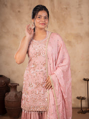 Half-length view of a peach silk kurta with sequin embroidery and a gold-bordered dupatta