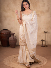 Front view of a model in a white silk salwar suit with a strappy floral-embroidered kurta, flared trousers and a gold-bordered dupatta