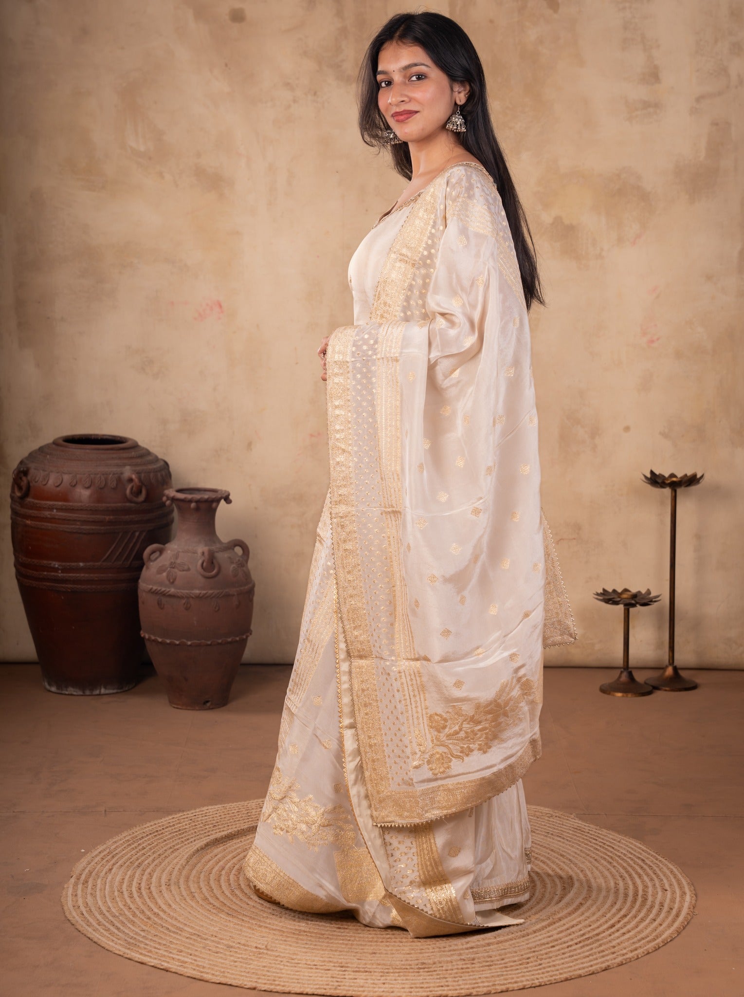 Side view of a white silk salwar suit with the dupatta draped over the shoulder