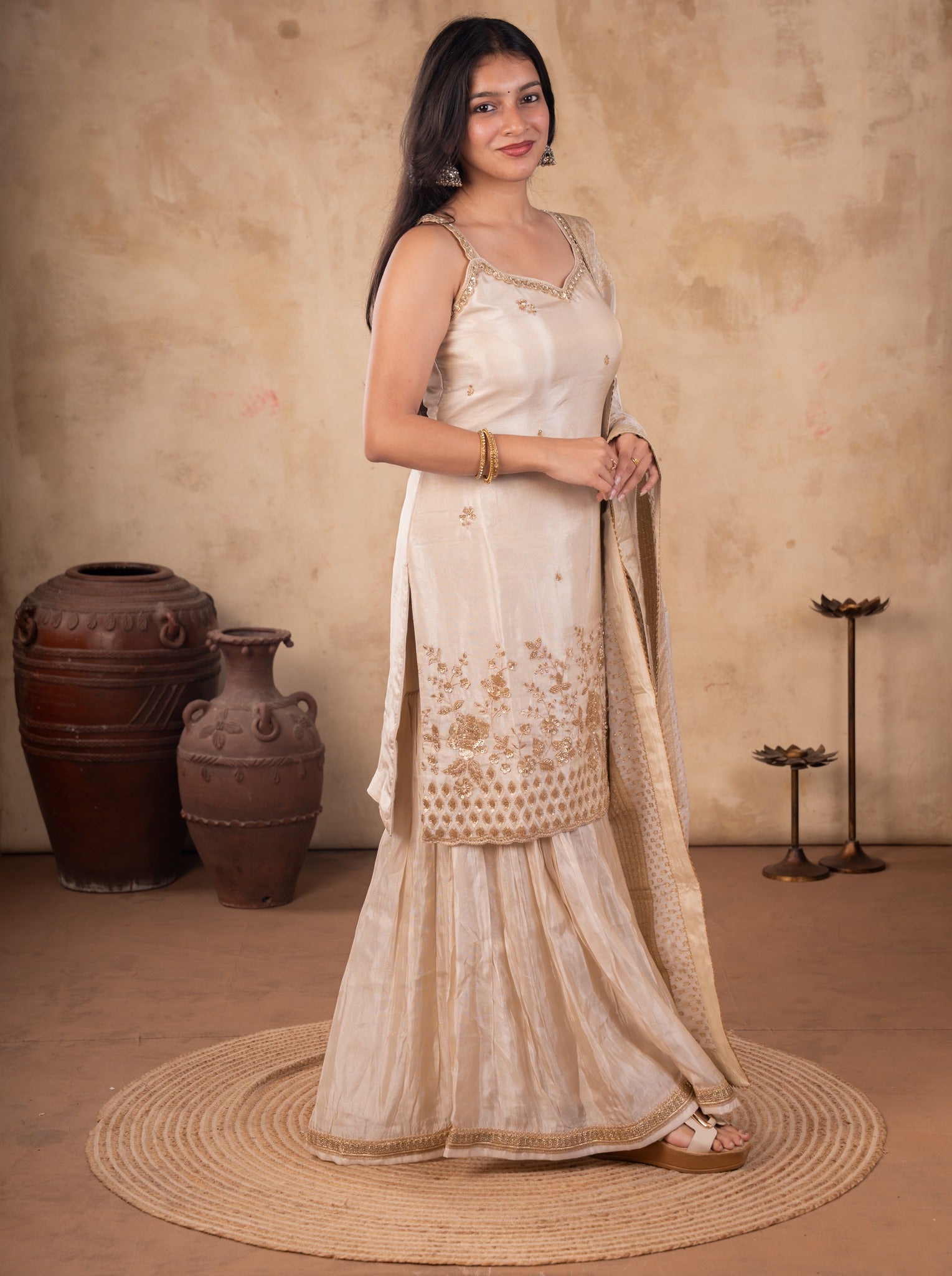 Full-length view of a white silk salwar suit with a strappy kurta and flared trousers