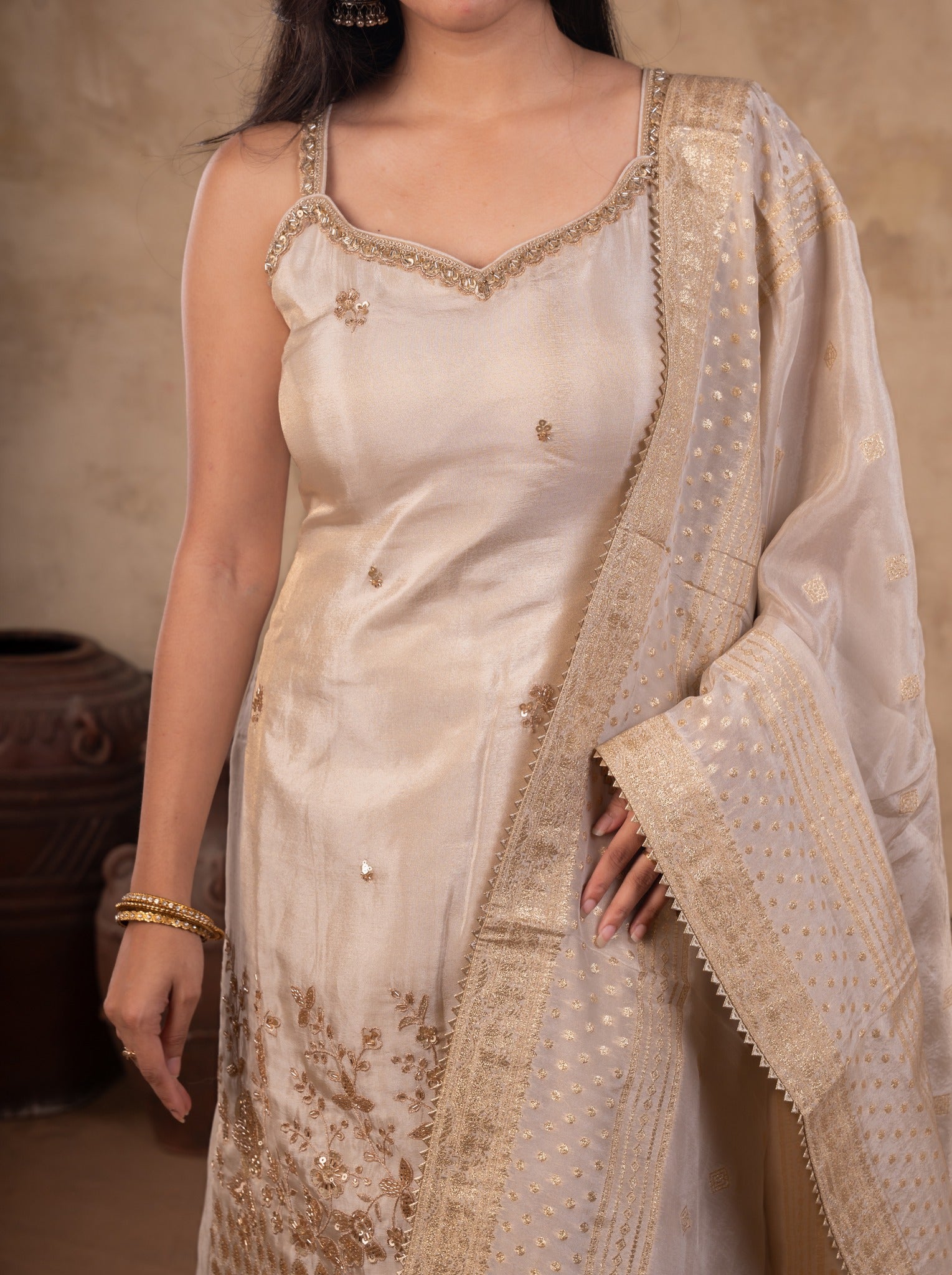 Close-up of the strappy white silk kurta with floral embroidery at the hem and the dupatta draped over the shoulder