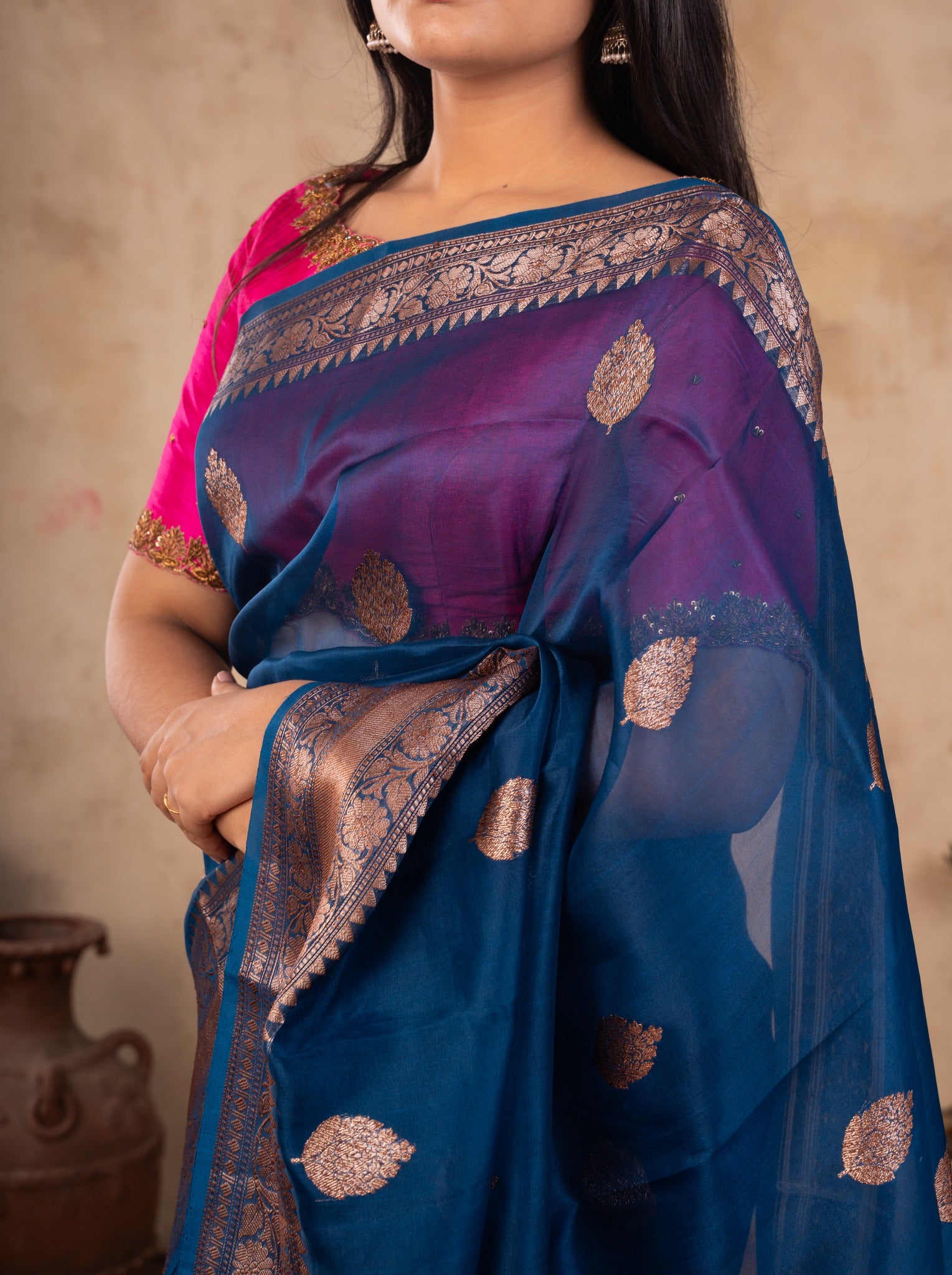 Close-up of the purple-toned border, metallic paisley motifs and pink blouse on a blue Banarasi silk saree