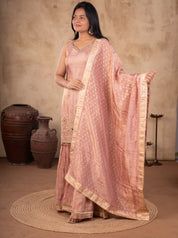 Model holding out the dotted blush pink dupatta over a georgette sharara suit
