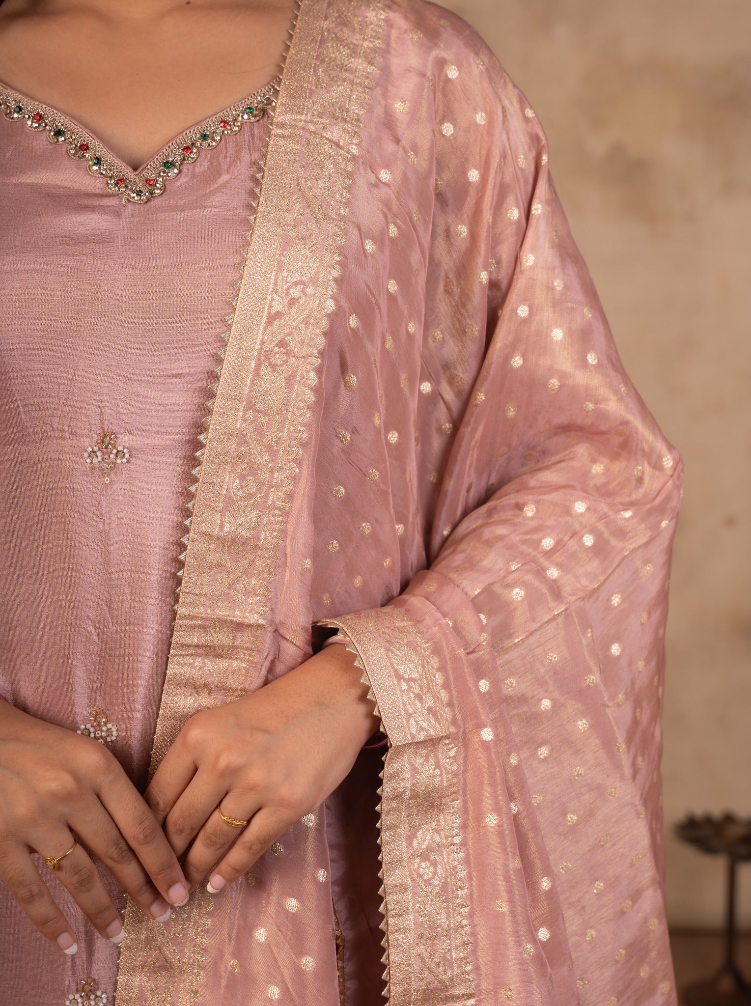 Close-up of the embellished V-neckline on a blush pink kurta with the dotted dupatta