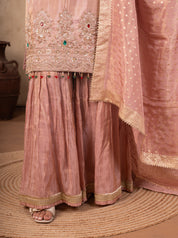 Detail of the embroidered kurta hem and flared blush pink sharara with a lace border