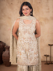 Model smiling in a light olive green georgette kurta with floral embellishments and a dupatta