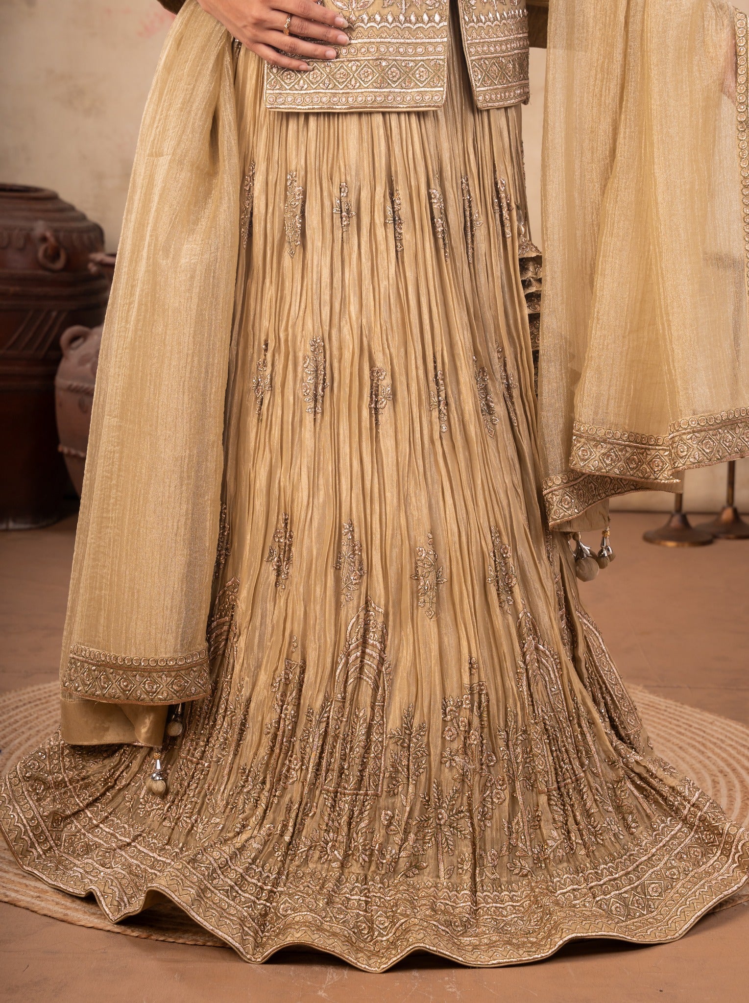Detail of the pleated crinkle skirt and ornate dupatta border on a pista organza lehenga