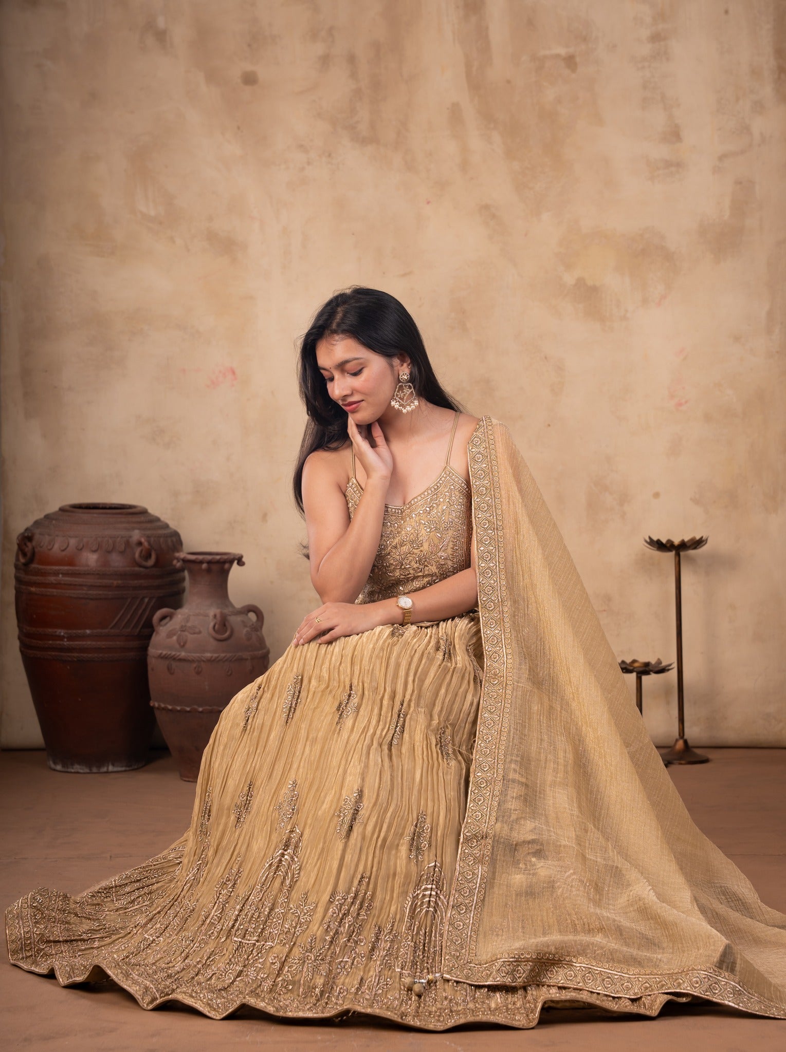 Seated pose in a pista organza lehenga with an embroidered choli and sheer dupatta