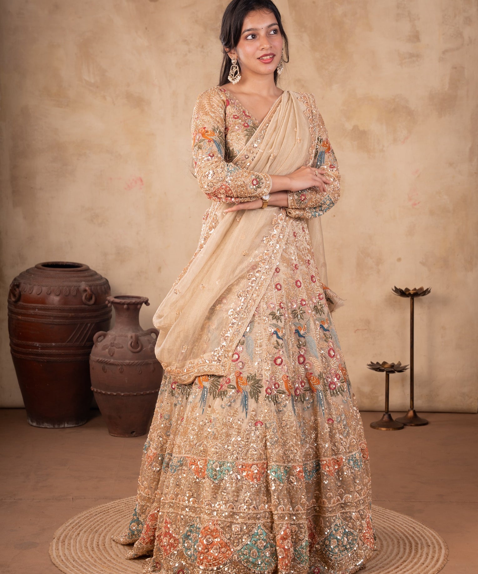 Model wearing a pista organza lehenga with multicoloured floral embroidery, an embellished long-sleeved blouse, and a matching dupatta with ornate trim.
