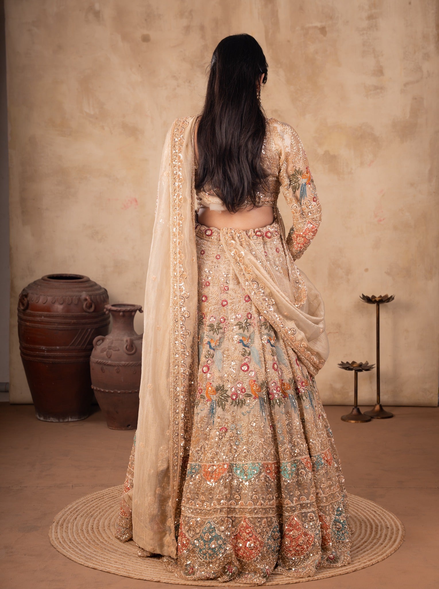 Back view of a pista organza lehenga showing the blouse back and the dupatta with ornate trim
