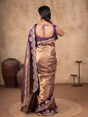 Back view of a bronze-toned saree showing the purple blouse back and embroidered pallu border