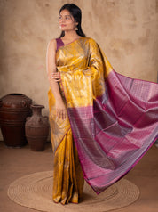 Model holding out the pink woven pallu of a mustard soft silk saree