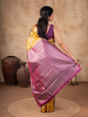 Back view of a mustard soft silk saree with the pink and silver woven pallu held out