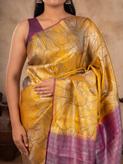 Close-up of the floral woven motifs on a mustard soft silk saree with a purple blouse
