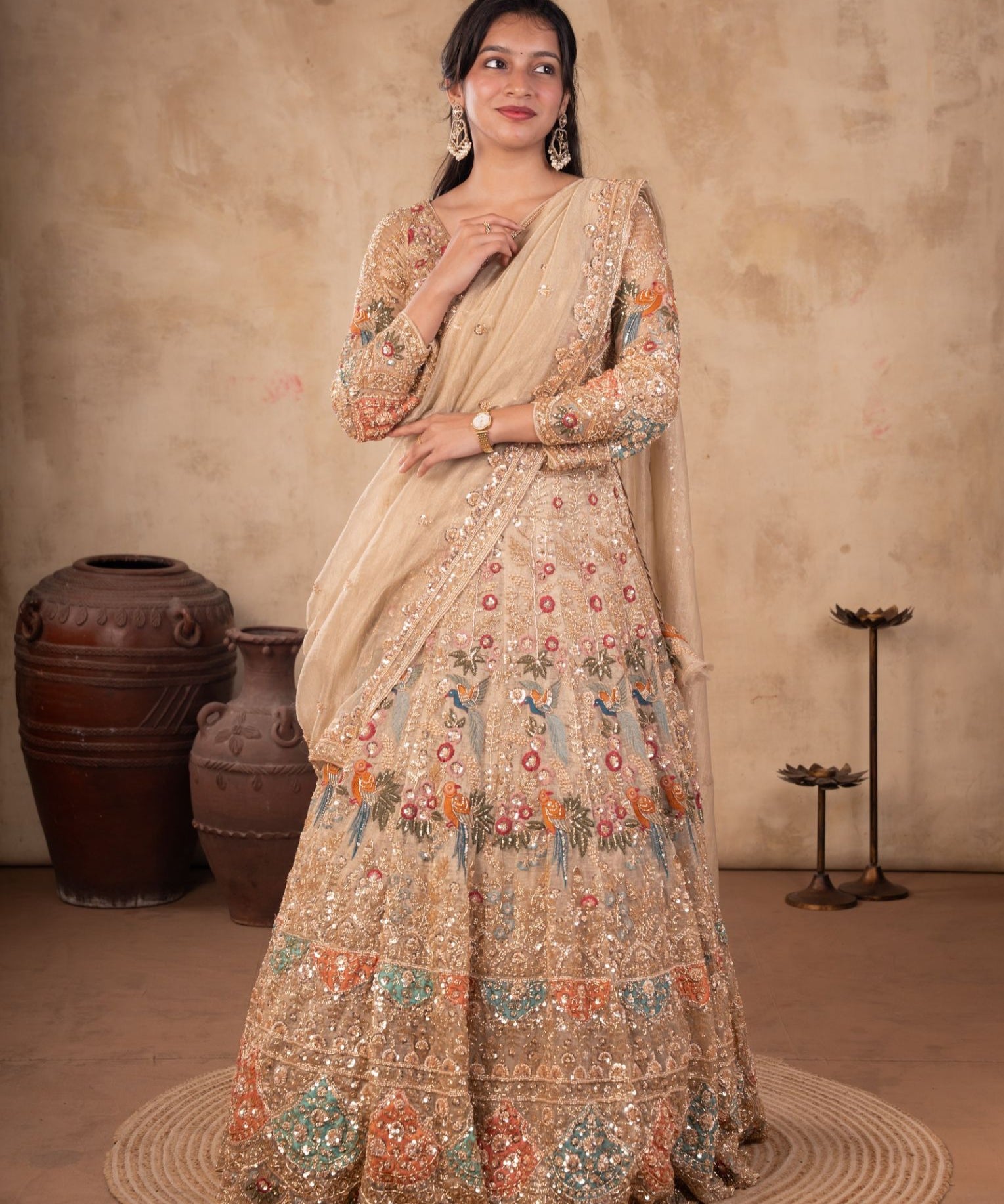 Model wearing a pista organza lehenga with multicoloured floral embroidery, an embellished long-sleeved blouse, and a matching dupatta with ornate trim.