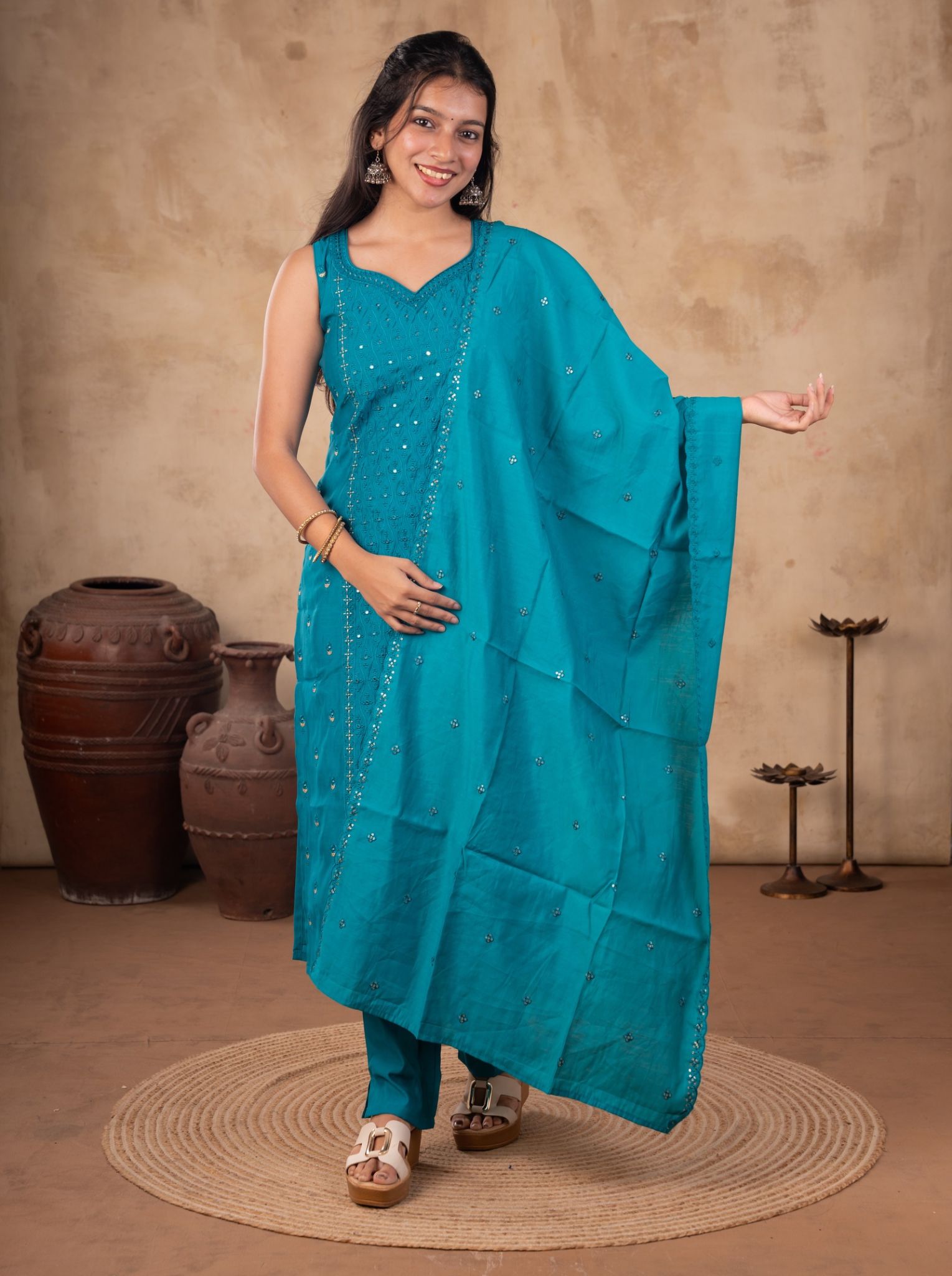 Model wearing a Rama teal cotton salwar suit with a sleeveless embellished kurta, matching trousers, and a dupatta with scattered motifs.