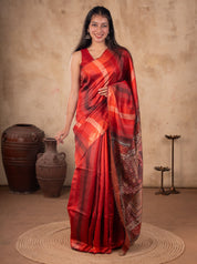 Model wearing a maroon Tussar silk saree with red and orange checks, an ornate paisley-patterned pallu, and a matching sleeveless blouse.